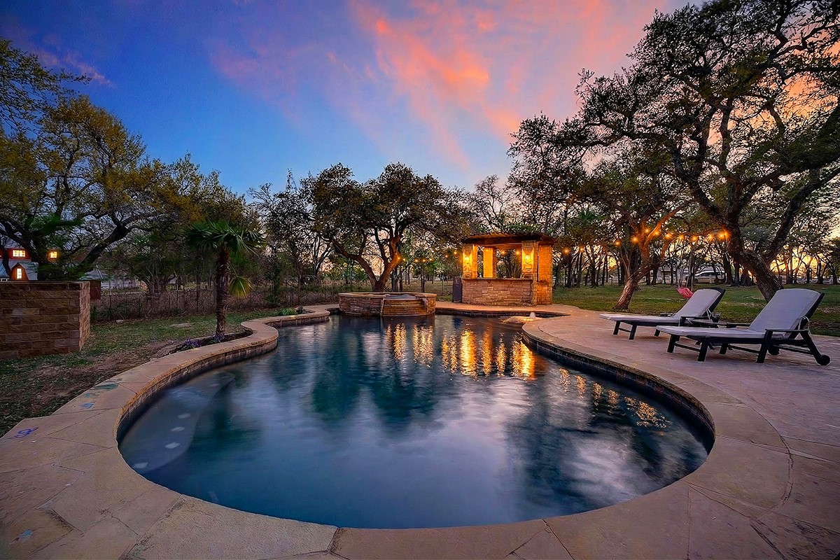301 Medlin Creek Loop Dripping Springs, TX 78620 - Photo 3 of 40 Pool at dusk with a patio and a pool with connected hot tub