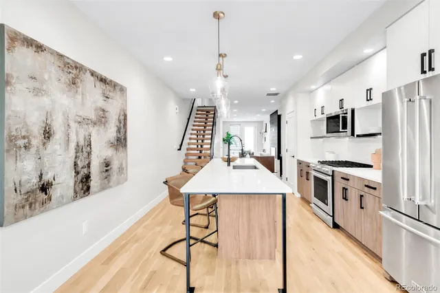 a kitchen with stainless steel appliances kitchen island a stove a sink a refrigerator and a refrigerator