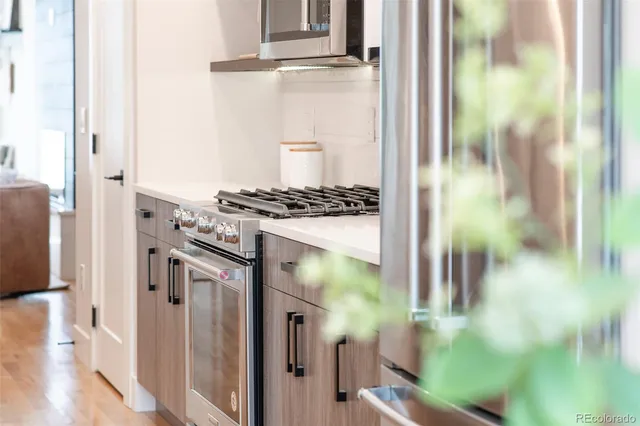 a kitchen with stainless steel appliances granite countertop a stove and a glass door