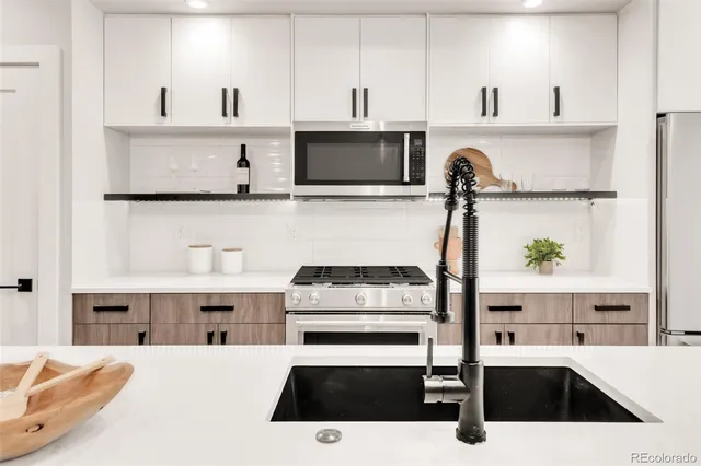 a kitchen with a sink a stove and cabinets