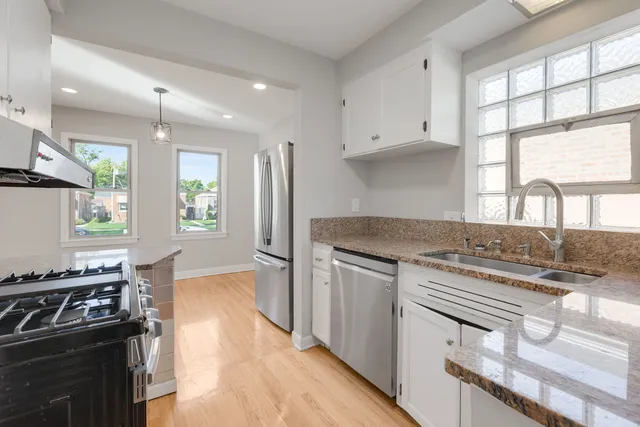 a kitchen with a stove a sink and a window