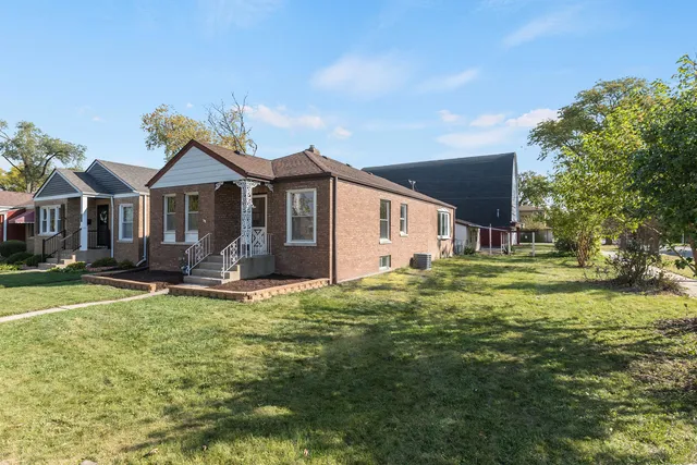 a view of a house with a big yard and large trees