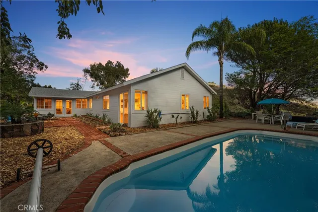a view of a house with backyard and sitting area