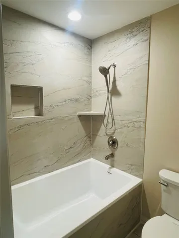 an aerial view of a house with yard and trees in the background