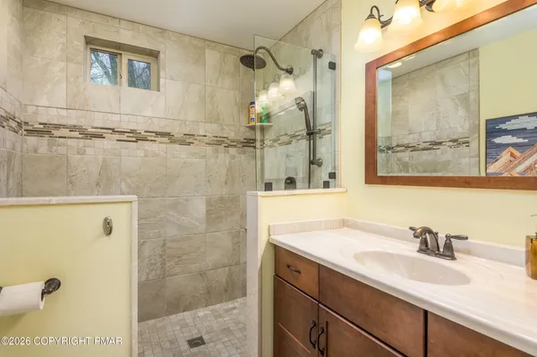 a bathroom with a shower sink and mirror