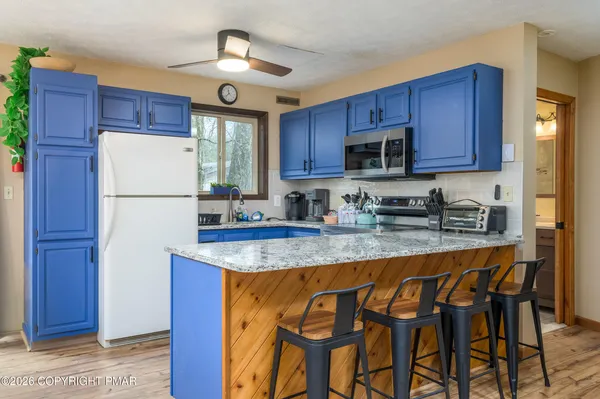 a kitchen with stainless steel appliances granite countertop wooden cabinets a stove a sink and a refrigerator