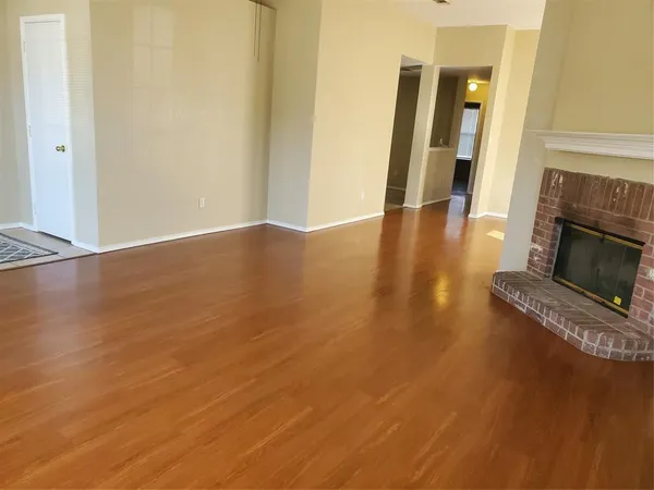 a view of a livingroom with wooden floor and a fireplace