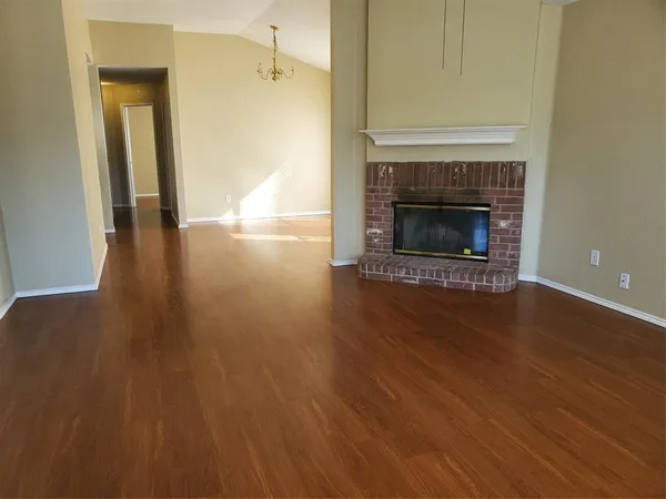 a view of a livingroom with wooden floor and a fireplace