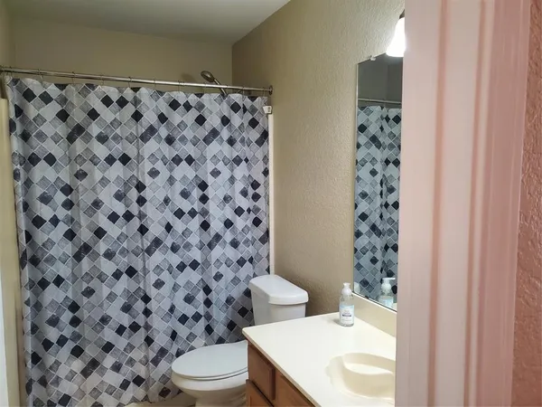 a bathroom with a toilet and a shower curtain