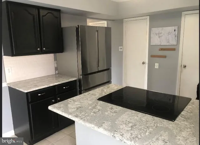 a kitchen with stainless steel appliances granite countertop a refrigerator and a stove