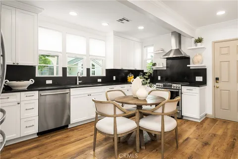 a kitchen with a sink cabinets and dining table chair