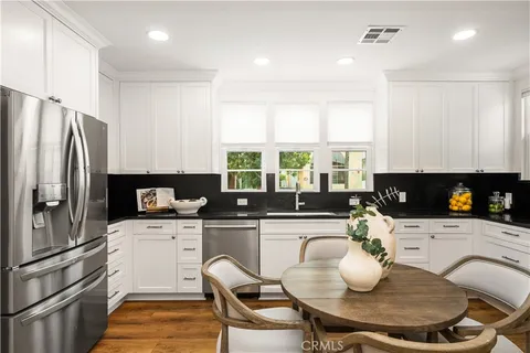 a kitchen with granite countertop a sink a counter space appliances and cabinets