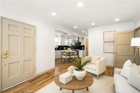 a living room with furniture a fireplace and a dining table with wooden floor