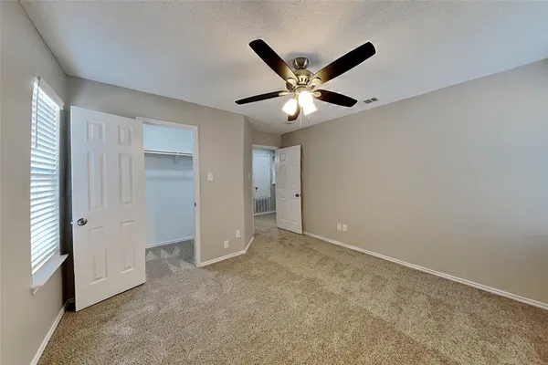 an empty room with closet and windows