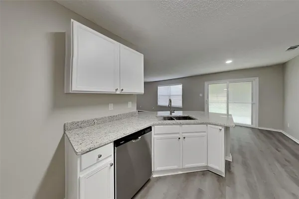 a kitchen with granite countertop a sink and cabinets