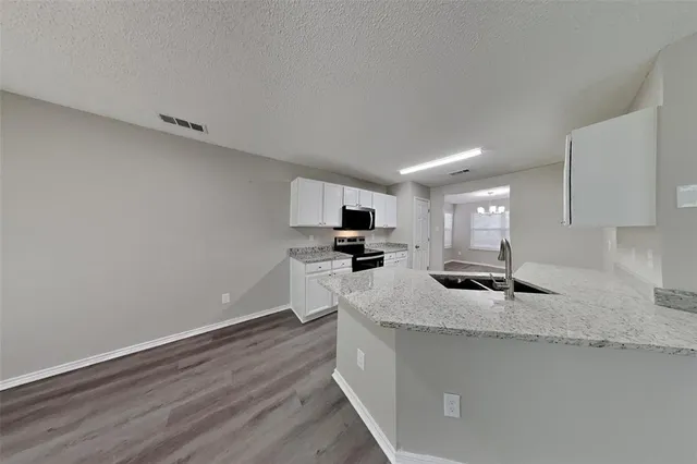 a kitchen with granite countertop a sink and a stove top oven