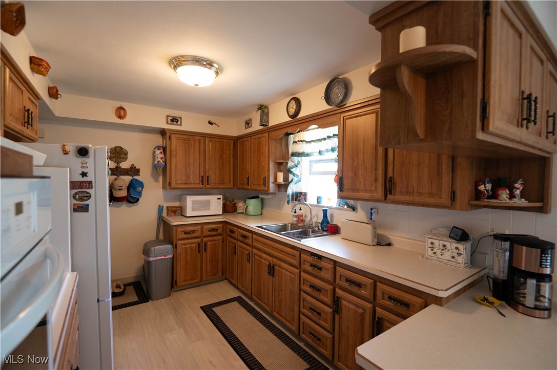 1074 South Meridian Road Youngstown, OH 44515 - Photo 15 of 42 Kitchen with open shelves, brown cabinets, and white appliances