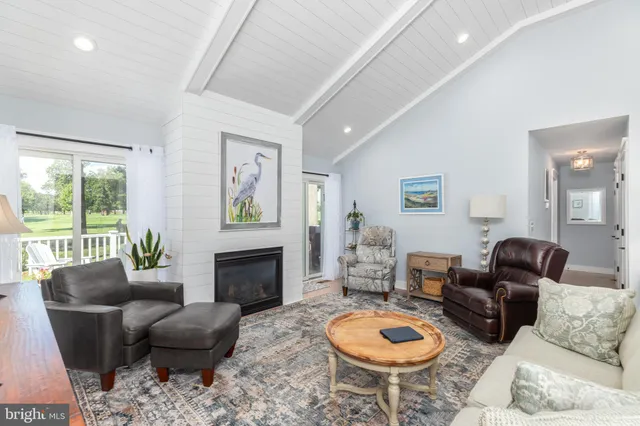 a dining room with furniture a large window and potted plants