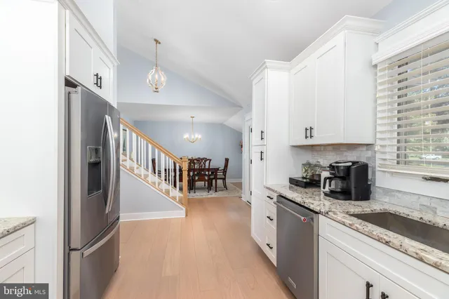 a kitchen with granite countertop a stove a sink and a microwave