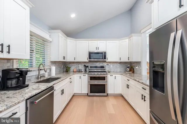 a kitchen with granite countertop a stove microwave and sink