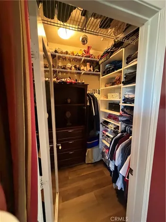 a view of walk in closet with clothes and shoes