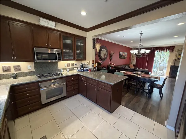 a kitchen with a stove sink cabinets and wooden floor