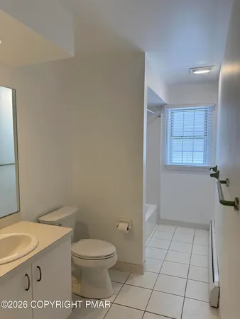 a bathroom with a granite countertop toilet and a sink
