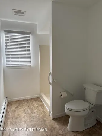 a bathroom with a toilet and a window