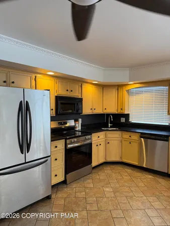 a kitchen with stainless steel appliances granite countertop a stove a sink and a refrigerator