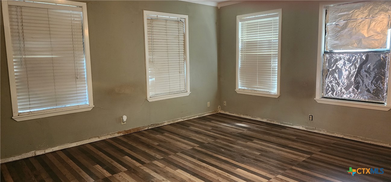 604 Davis Street Edna, TX 77957 - Photo 11 of 26 a view of an empty room with wooden floor and a window