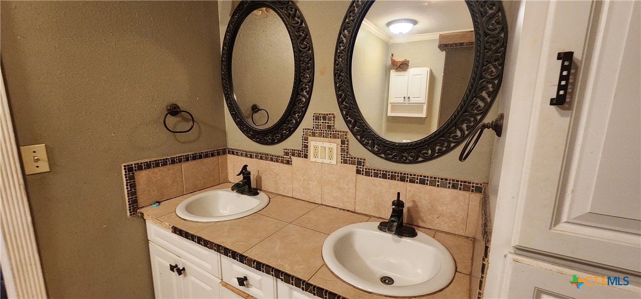 604 Davis Street Edna, TX 77957 - Photo 13 of 26 a bathroom with a sink and a mirror