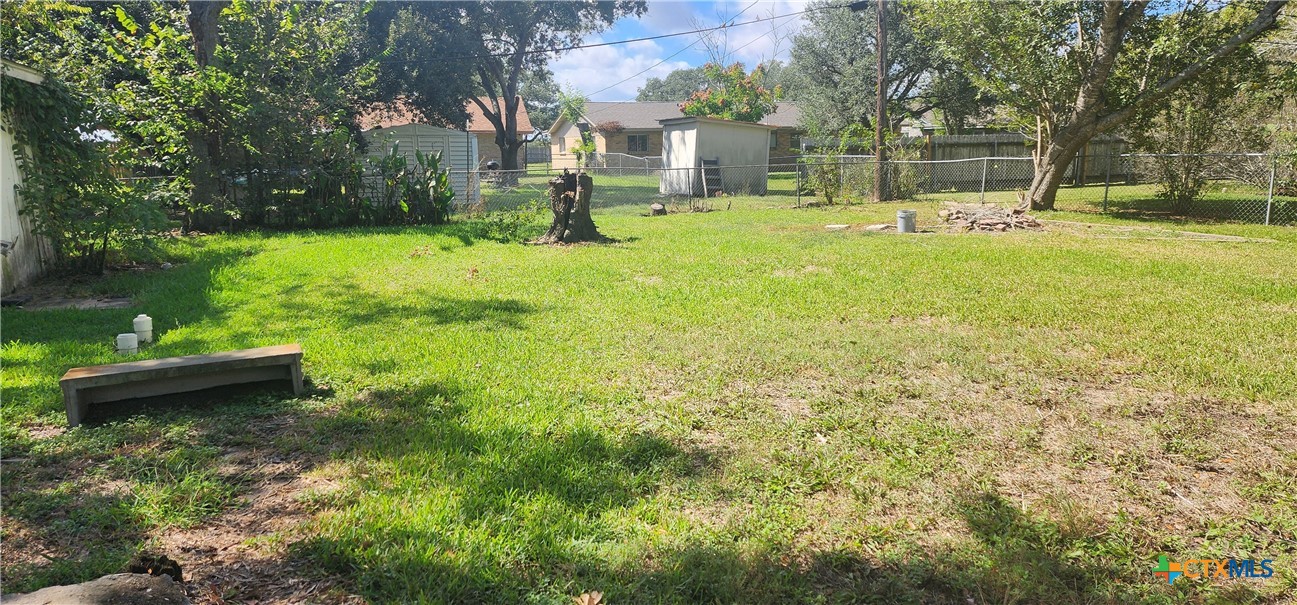 604 Davis Street Edna, TX 77957 - Photo 24 of 26 a view of a backyard with table and chairs and potted plants and large trees
