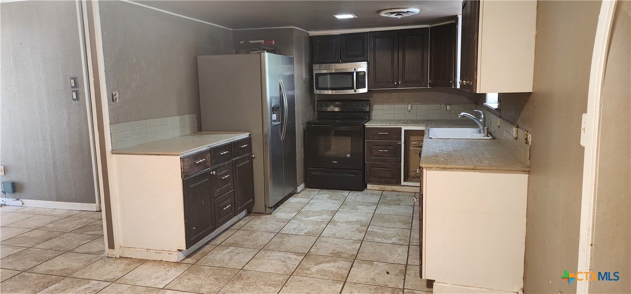 604 Davis Street Edna, TX 77957 - Photo 5 of 26 a kitchen with a refrigerator sink and stove