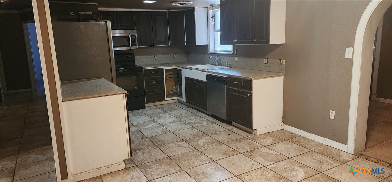 604 Davis Street Edna, TX 77957 - Photo 6 of 26 a kitchen with a sink stove and refrigerator
