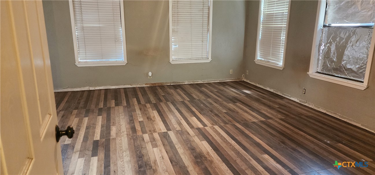 604 Davis Street Edna, TX 77957 - Photo 9 of 26 a view of an empty room with wooden floor and a window