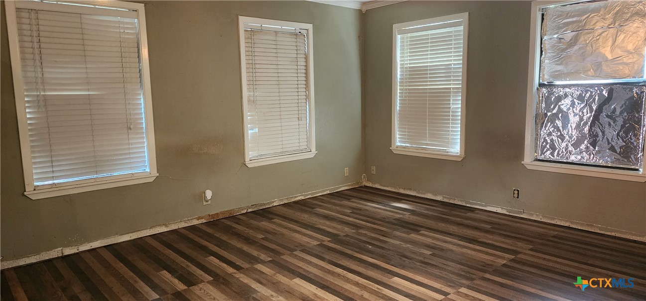 604 Davis Street Edna, TX 77957 - Photo 10 of 26 a view of an empty room with wooden floor and a window