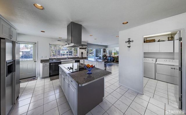 a kitchen with stainless steel appliances granite countertop a stove a sink dishwasher and a refrigerator