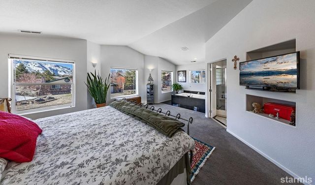 a bedroom with a bed and a flat screen tv