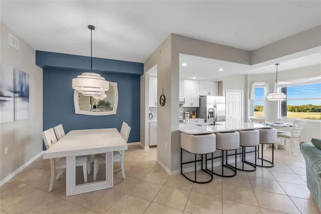 a large white kitchen with stainless steel appliances kitchen island granite countertop lots of counter top space