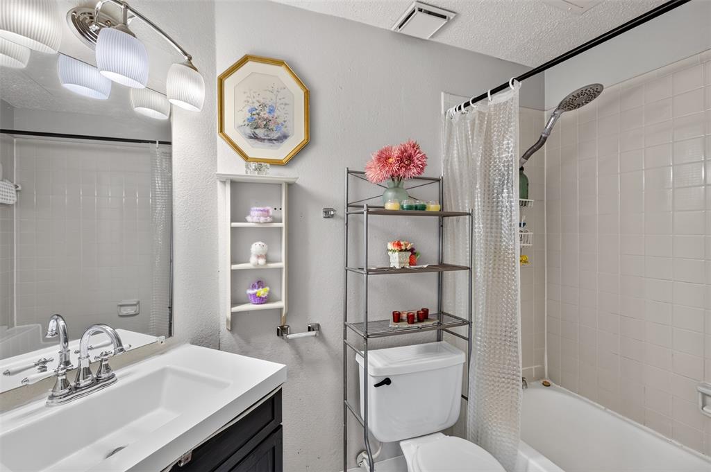 5550 Spring Valley Road, Unit G24 Dallas, TX 75254 - Photo 8 of 23 a bathroom with a sink a toilet and a mirror