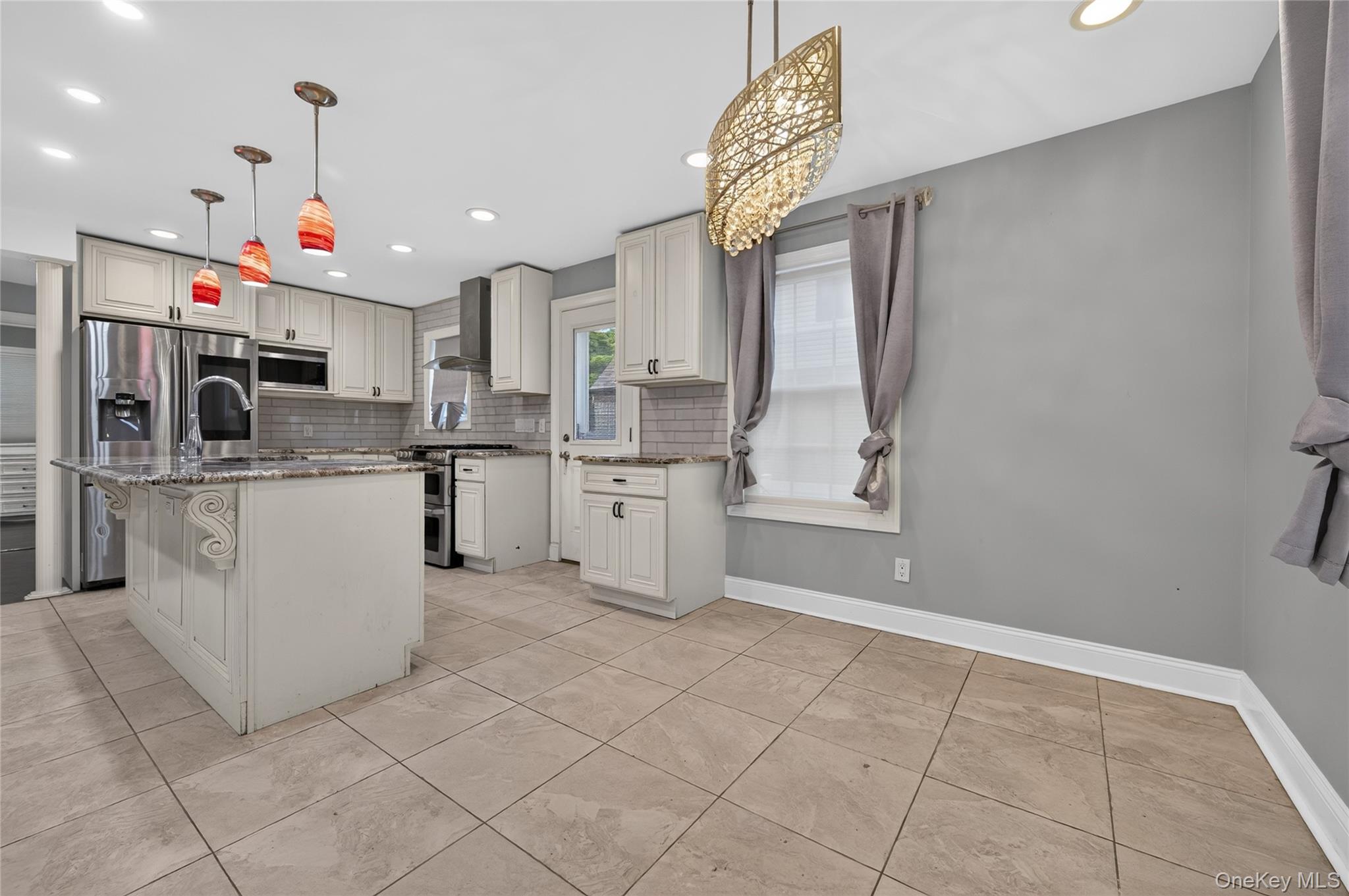 175 Wardwell Road Mineola, NY 11501 - Photo 10 of 25 a kitchen with white cabinets and white appliances