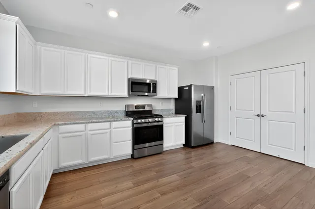 a kitchen with a refrigerator stove and white cabinets