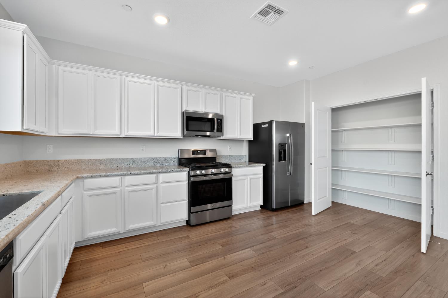 12829 Scholarly Way Rancho Cordova, CA 95742 - Photo 17 of 33 a kitchen with a refrigerator stove and white cabinets
