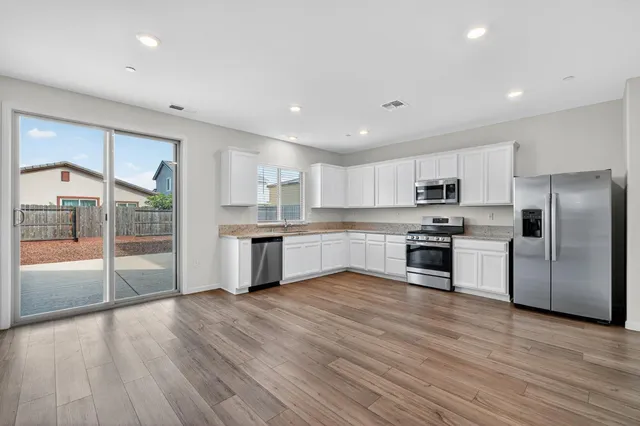 a kitchen with stainless steel appliances a refrigerator and wooden floor