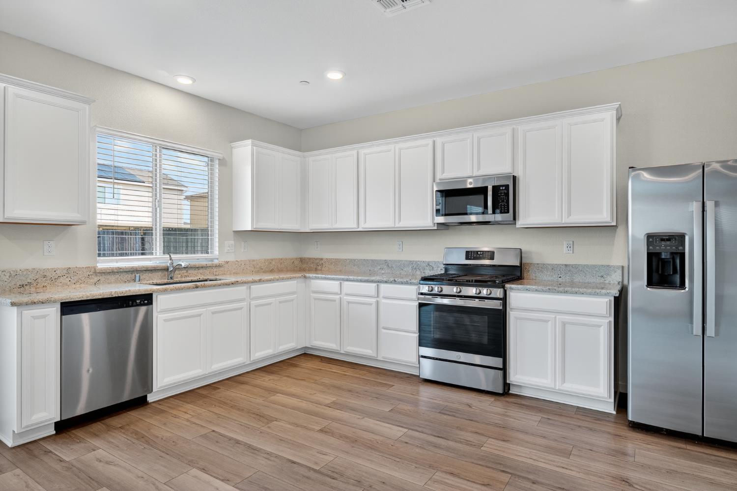 12829 Scholarly Way Rancho Cordova, CA 95742 - Photo 20 of 33 a kitchen with stainless steel appliances granite countertop a stove a sink and a microwave
