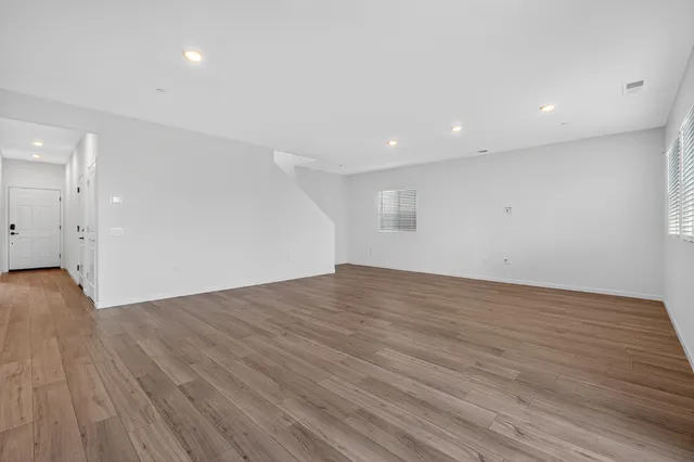 a view of empty room with wooden floor