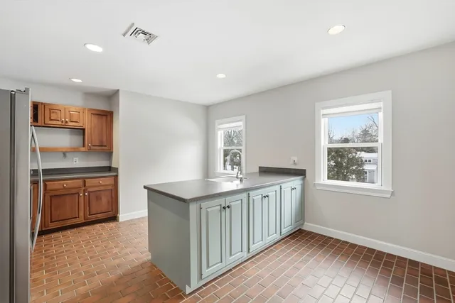 a kitchen with granite countertop a sink stove and cabinets