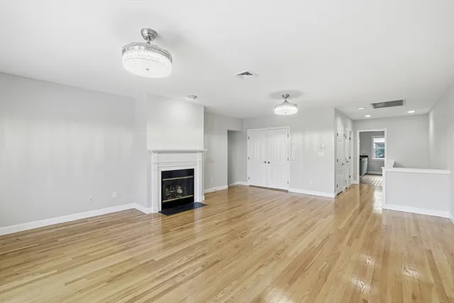 an empty room with wooden floor and a fireplace