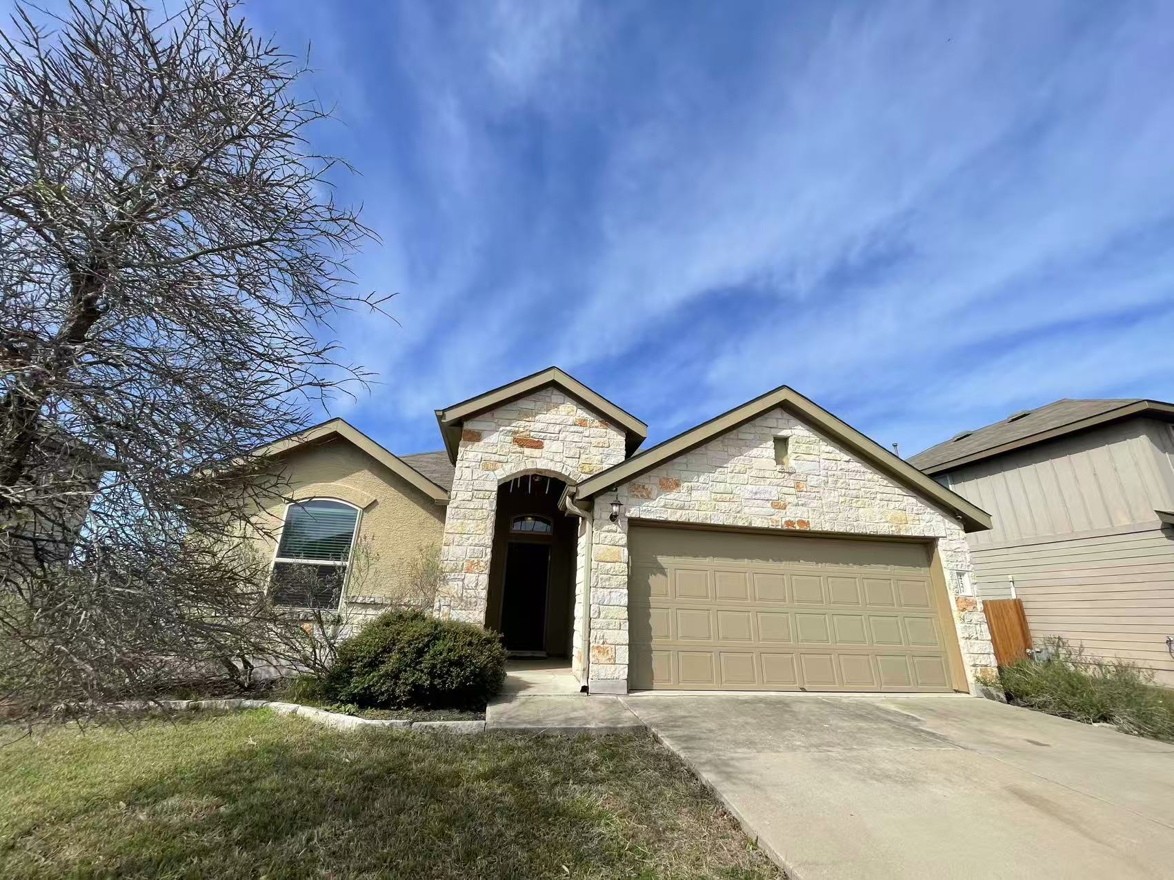 457 Dragon Ridge Road Buda, TX 78610 - Photo 1 of 29 French country inspired facade with stone siding, an attached garage, concrete driveway, and a front yard