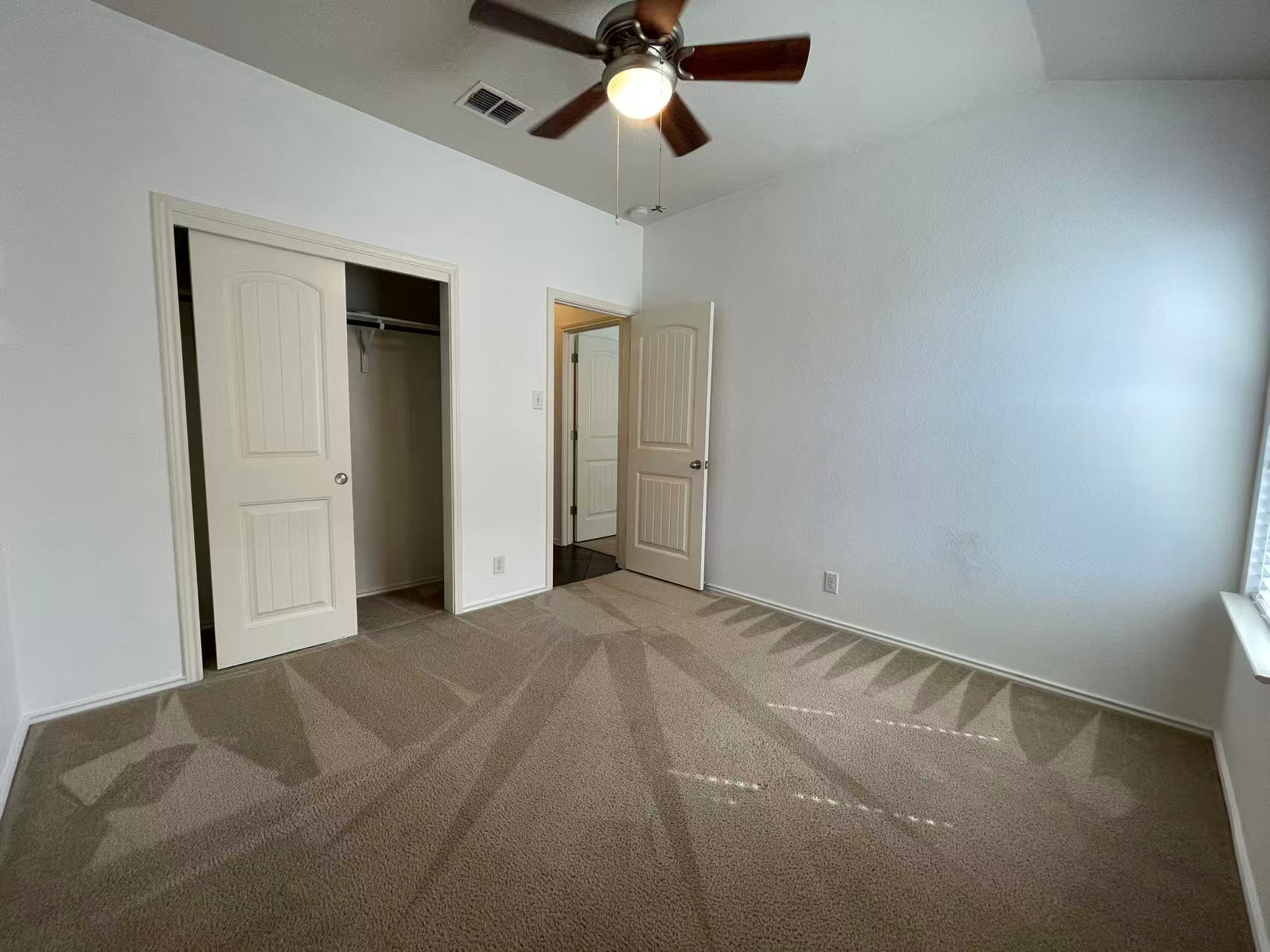 457 Dragon Ridge Road Buda, TX 78610 - Photo 11 of 29 Unfurnished bedroom with light carpet, a closet, and a ceiling fan